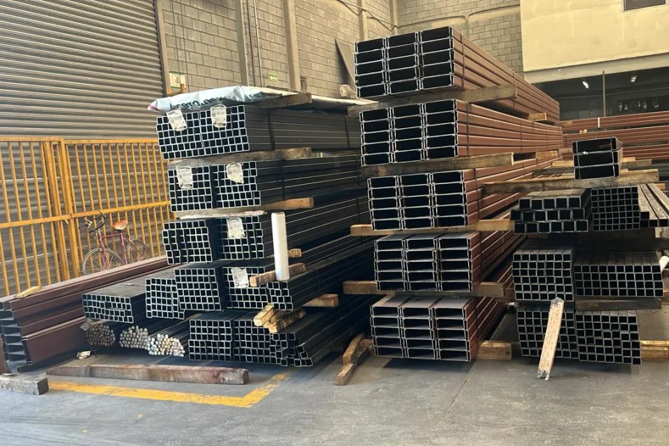 Perfiles de acero organizados en almacén para preparar un pedido