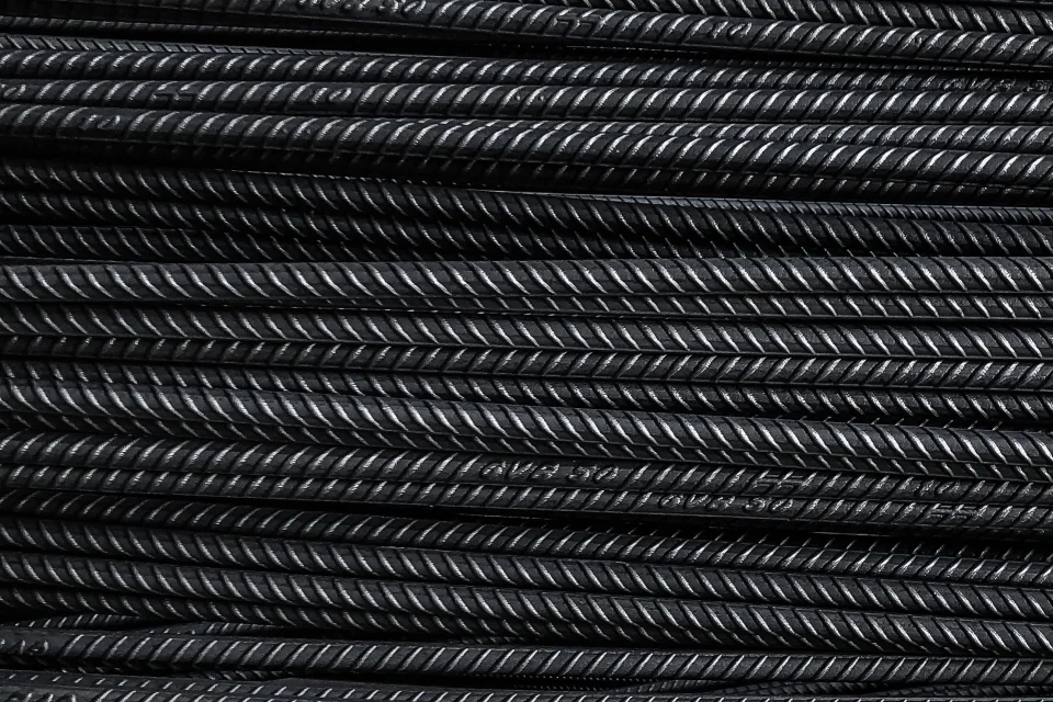 Straight ribbed reinforcing bars stacked and ready to be cut to length