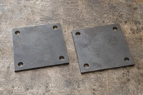 Dos placas base de acero con cuatro barrenos de montaje