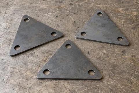 Tres cartabones triangulares planos con agujeros de fijación